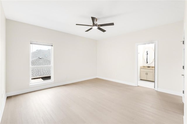 empty room featuring baseboards, light wood-style floors, and a ceiling fan