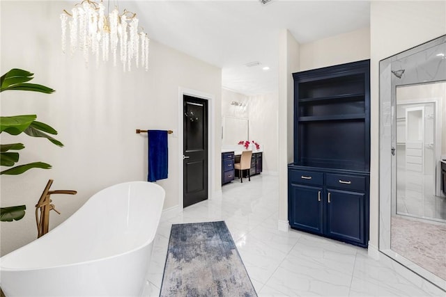 full bathroom with a notable chandelier, marble finish floor, and a freestanding bath