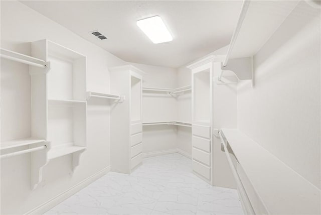 walk in closet with visible vents and marble finish floor