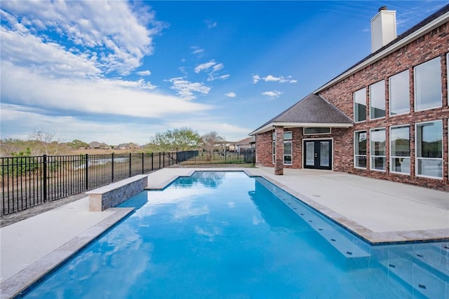 view of swimming pool with a patio area, a fenced in pool, french doors, and a fenced backyard