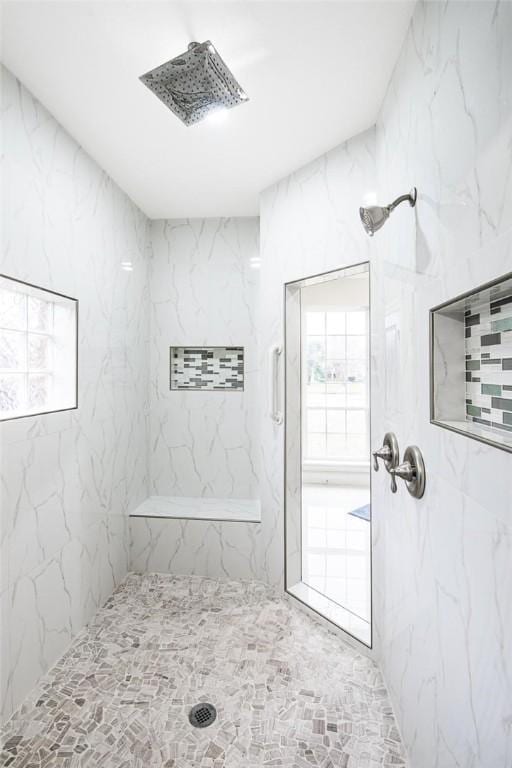 bathroom featuring a marble finish shower