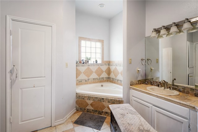 bathroom with tile patterned flooring, vanity, and tiled tub