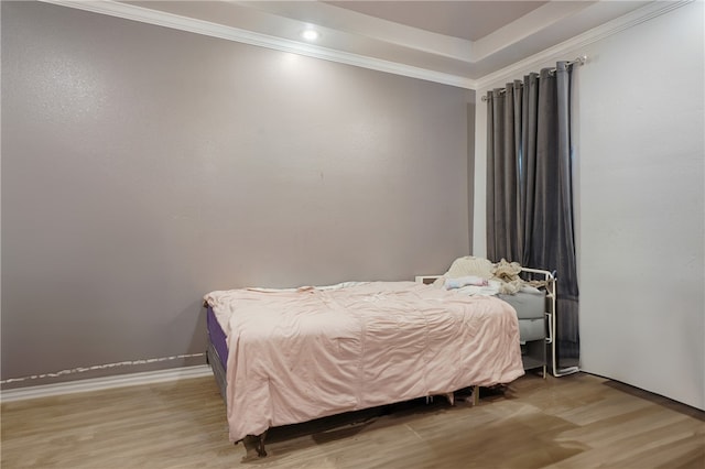 bedroom with hardwood / wood-style flooring and crown molding