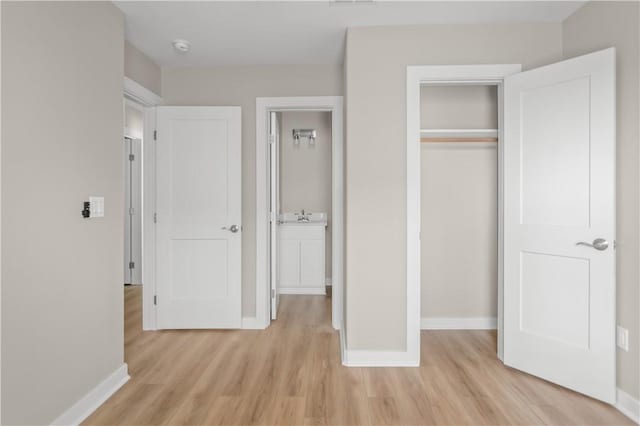 unfurnished bedroom with light hardwood / wood-style flooring and a closet