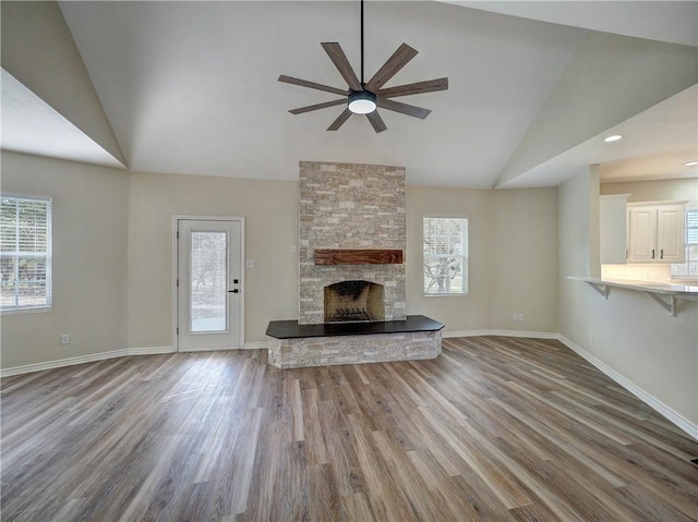 12631 Leopard St, Corpus Christi, TX 78410 - unfurnished living room with ceiling fan, healthy amount of natural light, wood finished floors, a stone fireplace, and high vaulted ceiling