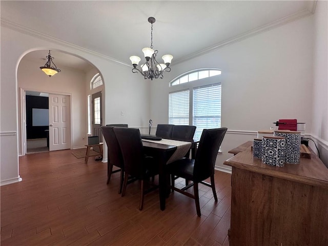 dining area featuring arched walkways, plenty of natural light, and ornamental molding