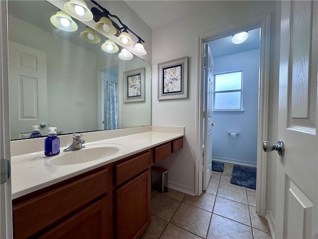 bathroom featuring vanity, baseboards, and tile patterned floors