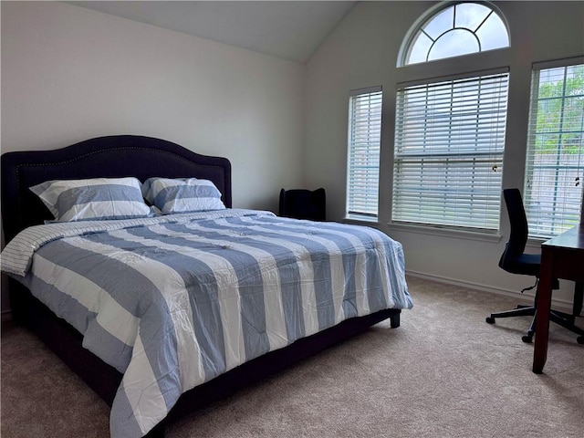 carpeted bedroom with baseboards and vaulted ceiling