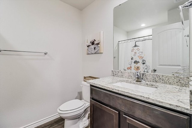 bathroom featuring toilet, hardwood / wood-style floors, vanity, and curtained shower