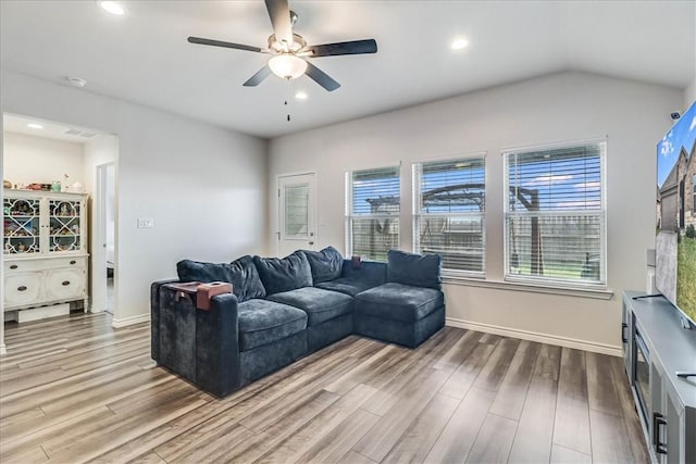 living room with ceiling fan, lofted ceiling, and hardwood / wood-style flooring