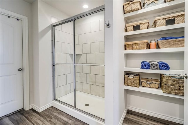 bathroom with hardwood / wood-style flooring and walk in shower