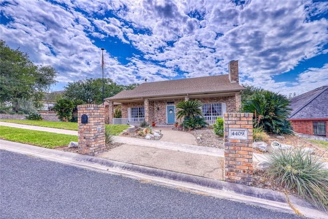 4409 Sue Cir, Corpus Christi, TX 78410 - view of front of home with a chimney, covered porch, fence, and brick siding