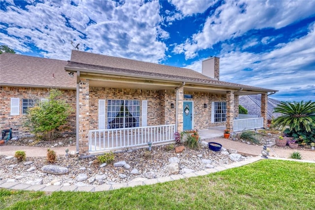 4409 Sue Cir, Corpus Christi, TX 78410 - view of front facade featuring brick siding, a front lawn, covered porch, and a chimney