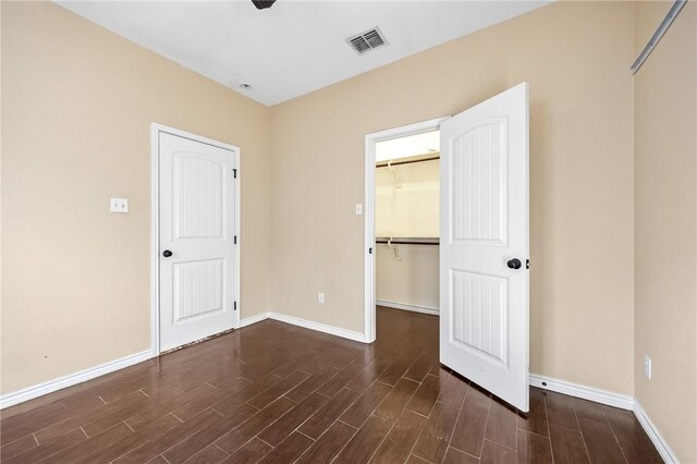 3813 Elvis Dr, Corpus Christi, TX 78414 - unfurnished bedroom featuring dark wood-type flooring, baseboards, a walk in closet, and a closet