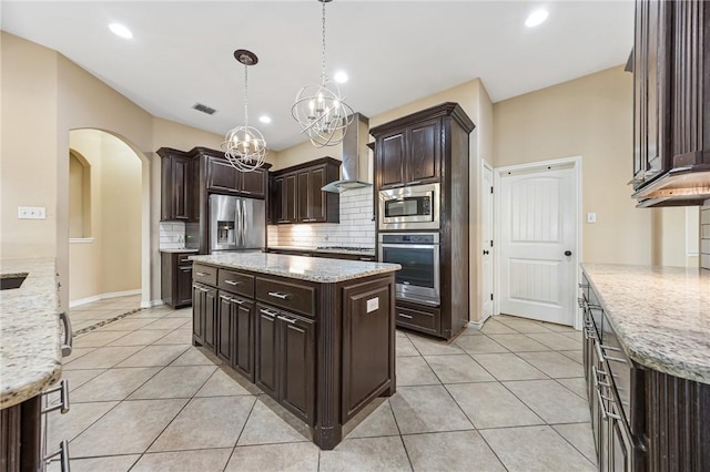 3813 Elvis Dr, Corpus Christi, TX 78414 - kitchen featuring appliances with stainless steel finishes, wall chimney exhaust hood, decorative backsplash, light tile patterned floors, and arched walkways