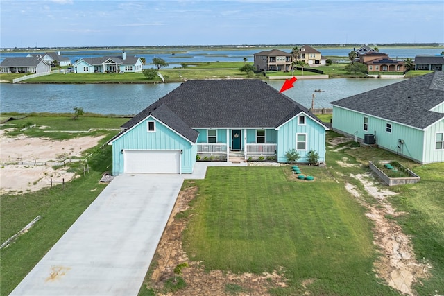 view of front of property with a front yard, a water view, and a garage