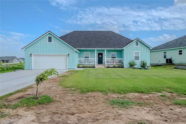 view of front facade with a garage, a front yard, covered porch, and central AC unit