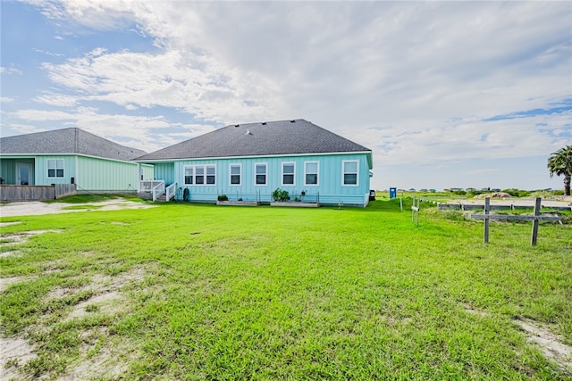 rear view of property featuring a lawn