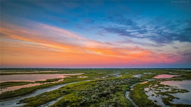 aerial view at dusk featuring a water view