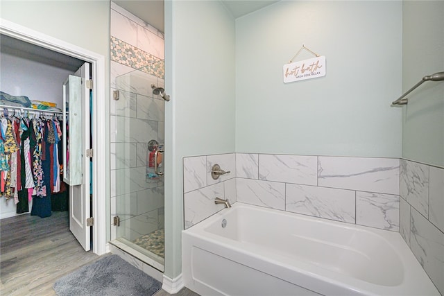 bathroom with shower with separate bathtub and wood-type flooring