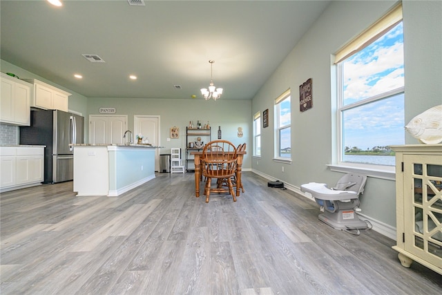 dining room featuring an inviting chandelier and light hardwood / wood-style flooring