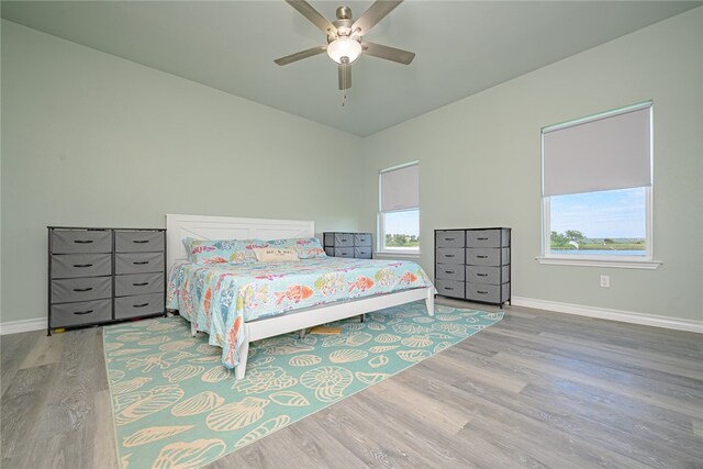 bedroom with multiple windows, hardwood / wood-style floors, and ceiling fan