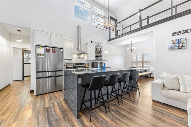 kitchen featuring stainless steel appliances, dark stone countertops, high vaulted ceiling, white cabinets, and dark hardwood / wood-style flooring