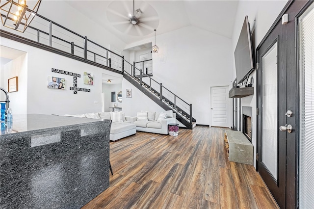 living room with dark wood-type flooring, high vaulted ceiling, and ceiling fan