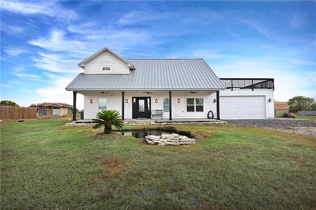 view of front of home with a front yard, a garage, and covered porch