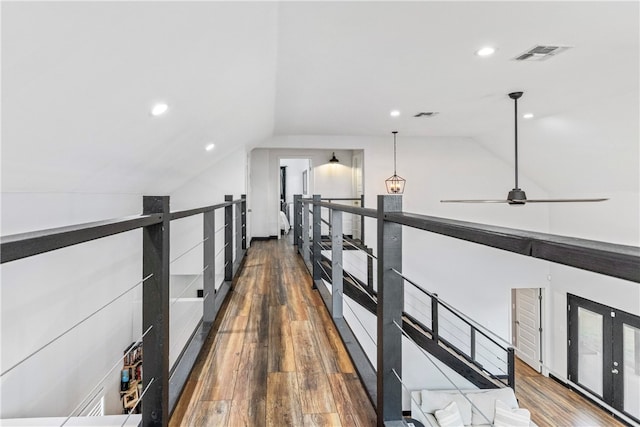 corridor with dark hardwood / wood-style flooring and lofted ceiling