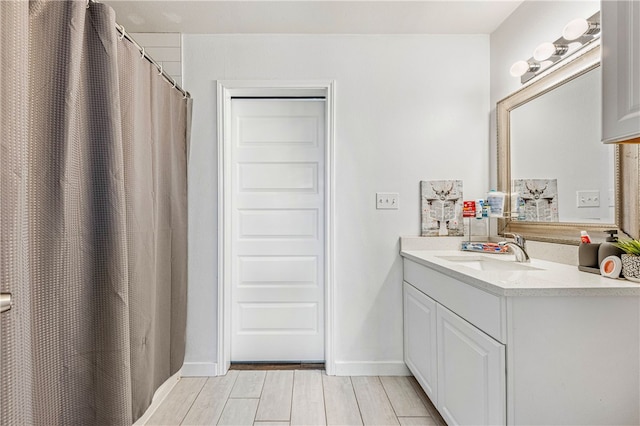 bathroom with hardwood / wood-style flooring, vanity, and curtained shower