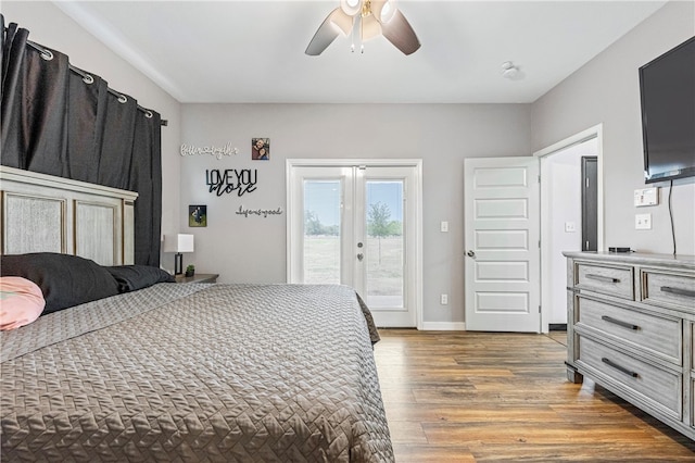 bedroom with french doors, access to outside, dark hardwood / wood-style flooring, and ceiling fan