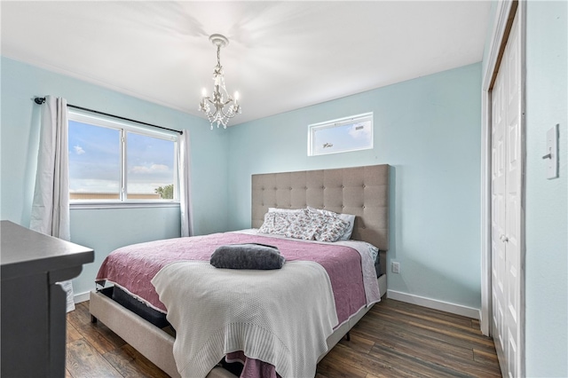 bedroom with dark hardwood / wood-style floors, a closet, and a chandelier