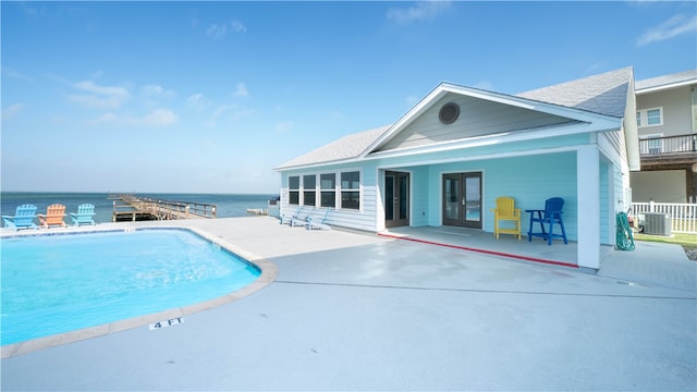 view of swimming pool with a water view, cooling unit, and a patio area