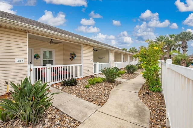 view of exterior entry featuring ceiling fan and a porch