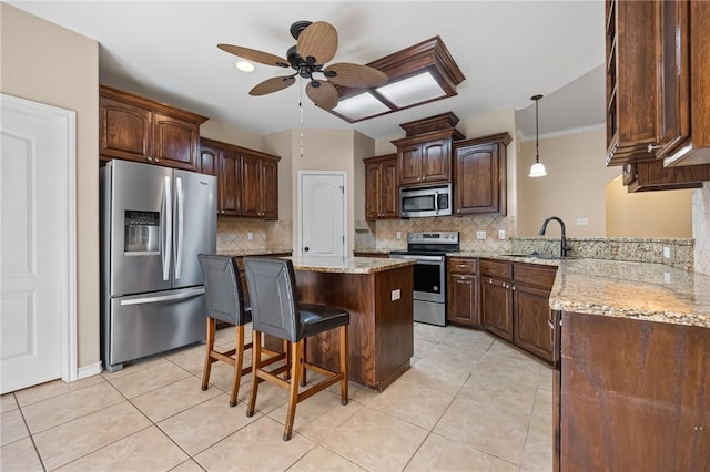 7406 Brush Creek Dr, Corpus Christi, TX 78414 - kitchen featuring stainless steel appliances, a sink, ceiling fan, a breakfast bar area, and decorative backsplash