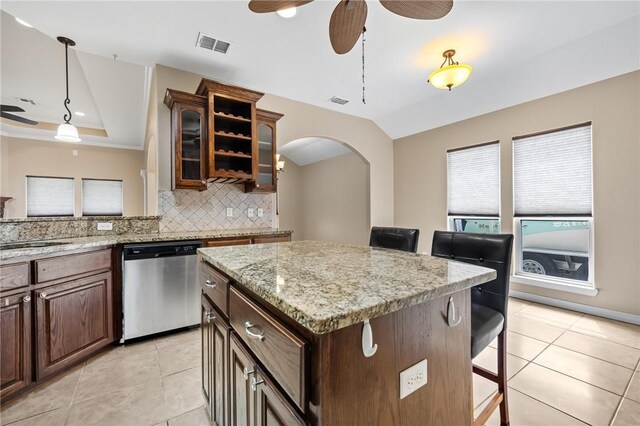 7406 Brush Creek Dr, Corpus Christi, TX 78414 - kitchen featuring stainless steel dishwasher, a ceiling fan, a breakfast bar area, tasteful backsplash, and light tile patterned floors