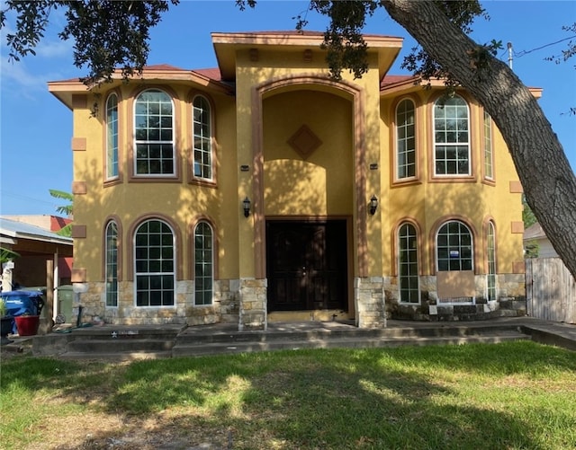 mediterranean / spanish home with a front yard