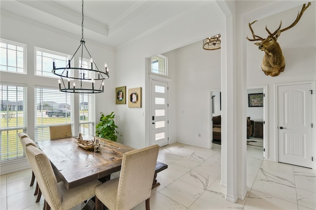 dining space with a chandelier, crown molding, and a towering ceiling