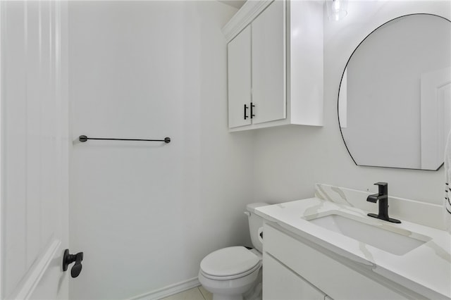 bathroom with tile patterned flooring, vanity, and toilet