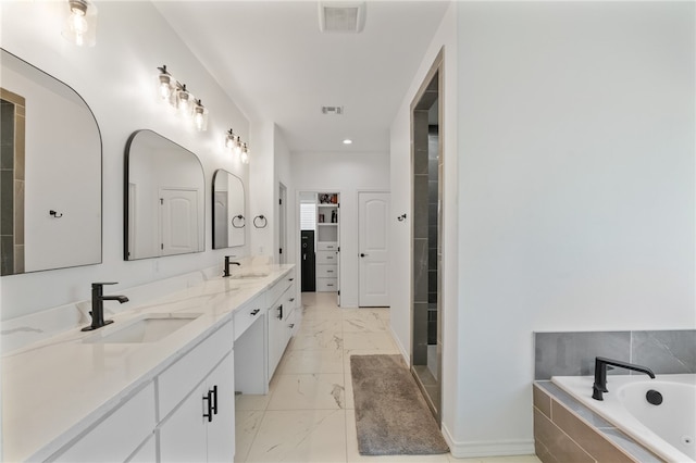 bathroom featuring a relaxing tiled tub and vanity