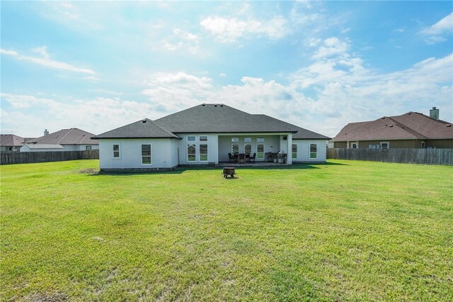 rear view of house featuring a patio and a yard