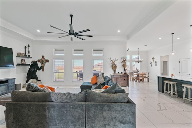 living room featuring ceiling fan with notable chandelier and crown molding