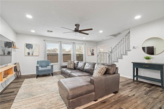 living area featuring recessed lighting, dark wood-style flooring, visible vents, and stairway