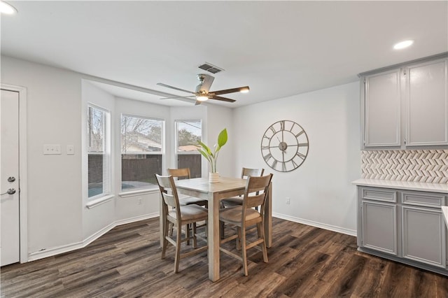 dining room with dark wood-style floors, visible vents, and baseboards