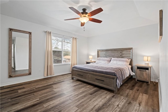 bedroom with ceiling fan, baseboards, and dark wood-type flooring