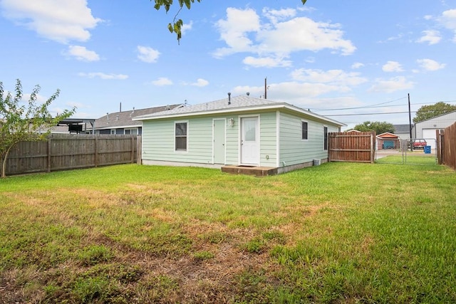 906 S Young St, Rockport, TX 78382 - back of property with a fenced backyard, a gate, and a lawn