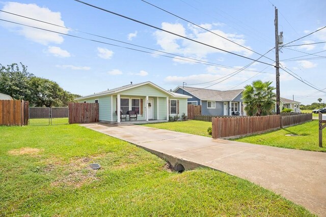 906 S Young St, Rockport, TX 78382 - view of front facade featuring a fenced front yard, a front yard, concrete driveway, and a gate