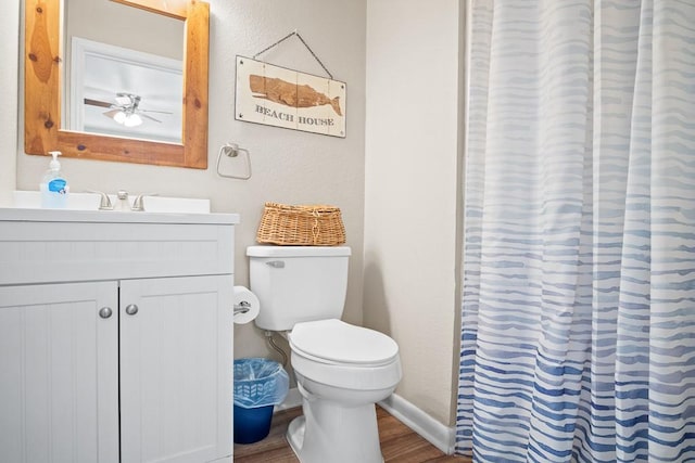 906 S Young St, Rockport, TX 78382 - bathroom featuring baseboards, a shower with shower curtain, toilet, vanity, and wood finished floors