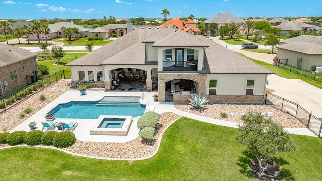 5716 S Oso Pkwy, Corpus Christi, TX 78414 - rear view of house featuring a balcony, stone siding, stucco siding, a patio area, and a residential view
